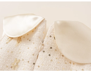 Détail d'une robe en tweed avec sequins dorés, col en satin et fermeture invisible