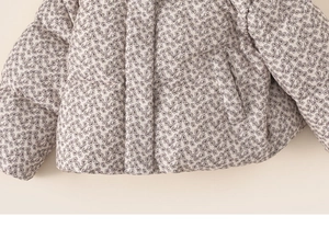 Close-up of girls' floral quilted jacket showing stitch patterns and side pockets