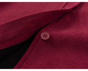 Detailed close-up of burgundy corduroy fabric with warm black fleece lining and buttons