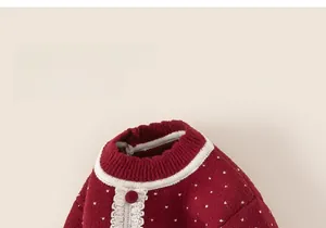 Detail of red kids sweater featuring white heart polka dots and delicate lace trim edge