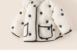 Detail of baby girl's polka dot padded winter jacket with high neck and large pockets