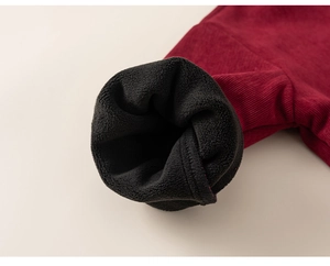Close-up of thick dark red corduroy fabric with warm black fleece lining detail