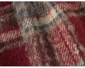 Close-up of red plaid wool fabric texture with soft brushed fibers and knit details