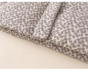 Detailed close-up of quilted floral cotton jacket hem with black and white flower patterns