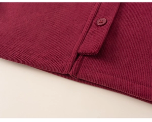 Macro detail of wine red ribbed knit fabric with matching buttons and side slit hem