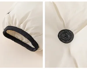 Detail of white padded jacket showing elastic cuffs and black polka dot embroidery