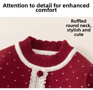 Detail view of girl's red polka dot knit sweater with white lace trim collar and button
