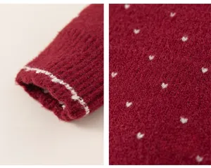 Macro detail of red knit sweater featuring white heart patterns and ribbed cuffs texture