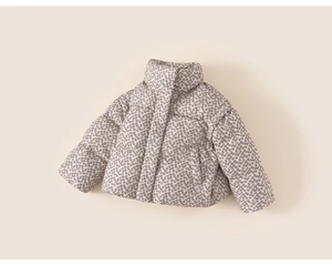 Detailed close-up of a floral girls winter jacket featuring high collar and quilted texture