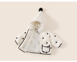 Detailed close-up of padded polka dot coat featuring black trim and decorative hood pompom