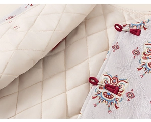 Detail of Chinese style vest featuring traditional lion jacquard fabric and red frog buttons