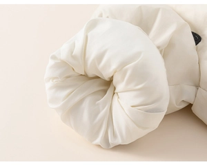 Detail of soft quilted white winter jacket sleeve showing padded texture and warm filling