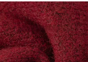 Detailed close-up of soft red knit fabric with long fluffy fibers for warm winter wear