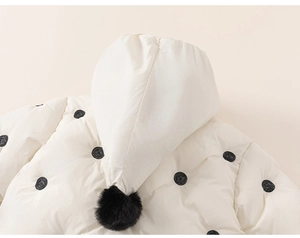 Detail of baby polka dot hooded jacket with soft faux fur pom-pom on the pointed hood