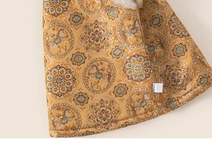 Macro shot of golden Chinese style fabric with traditional floral and horse patterns