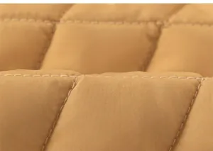 Macro detail of diamond quilted fabric with white contrast stitching on winter dress