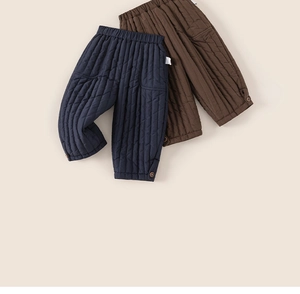 Detail of boys' quilted winter pants with elastic waist and decorative buttons on cuffs