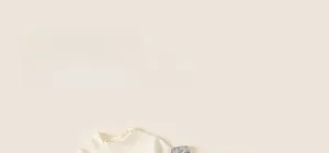 Close-up of cream knit sweater featuring sequin shoulders and ruffled high neck detail
