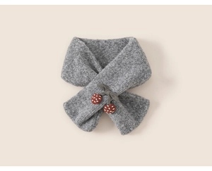 Detail of gray knitted scarf featuring cross design and cute brown bow embellishments