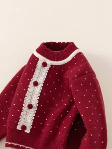Girl's red knit sweater with white polka dots, lace trim and plush pom-pom buttons