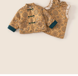 Detailed close-up of golden Chinese brocade kids winter jacket with traditional patterns