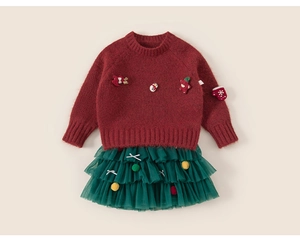 Close-up of knit texture and Christmas embroidery on red festive kids sweater
