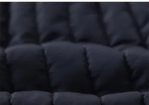 Detail of dark blue quilted fabric with horizontal stitching and subtle glossy finish