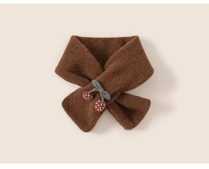 Detail of a thick brown knitted girls scarf with gray bow and red berry charms