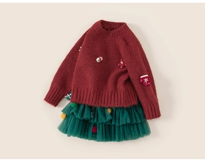 Detail of red Christmas knit sweater with snowman motifs and green tulle tutu skirt