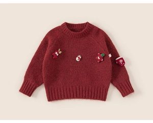 Detailed macro view of kids red festive knit sweater with Christmas 3D ornaments