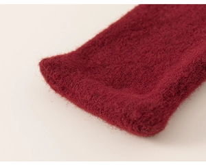 Close-up of wine red knitted scarf showing soft plush texture and warm material