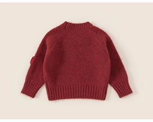 Detail of red plush knit sweater with ribbed cuffs and warm fluffy texture for kids