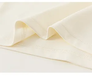 Detail view of child's dress showing fine stitching and soft cream knitted hem texture