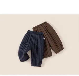 Detail of children's thick quilted pants in navy and coffee colors with elastic waist