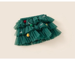 Detail of girls dark green layered tulle tutu skirt with colorful pom-poms and bows
