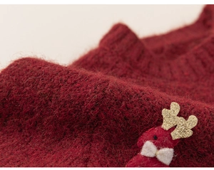 Close-up of knit fabric featuring a 3D reindeer with gold sequins and white bow