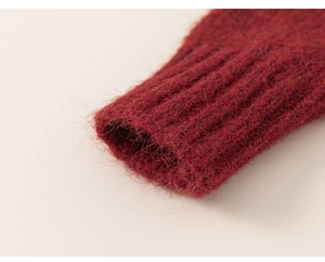 Detailed close-up of dark red knit sweater cuff with ribbed texture and fuzzy wool finish