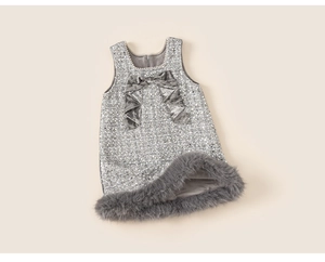 Nahaufnahme von silbernen Pailletten, Samtschleife und Pelzbesatz am Kleid für Mädchen