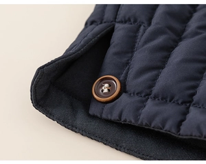 Detail view of navy blue quilted puffer pants with button and ribbed cuff finish