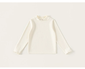 Detail of girls' cream knit turtleneck sweater with lettuce edge collar and cuffs