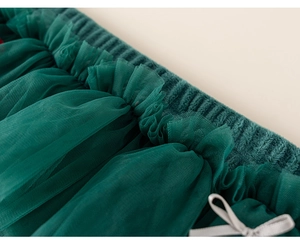 Detail of dark green layered tulle fabric with a delicate silver grey ribbon bow
