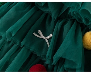 Detail of green layered tulle skirt with mesh fabric and festive pom-pom decorations