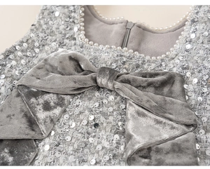 Nahaufnahme Mädchen Tweed Kleid mit silbernen Pailletten, Samtschleife und Perlen