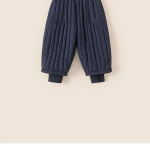 Close-up of kids quilted warm pants in dark blue with ribbed cuffs and side buttons