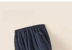Detail view of boys' winter quilted pants showing elastic waistband and striped stitching