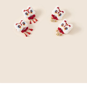 Détail de barrettes lion en peluche avec pompons rouges et cloches dorées pour enfants