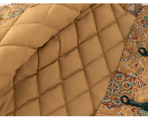 Macro detail of golden jacquard fabric with traditional Chinese embroidery and quilted lining