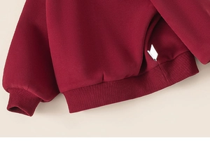 Détail du sweat à capuche bordeaux avec poignets élastiques et ourlet en polaire douce