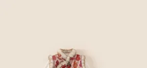 Detail of pink Chinese vest with calabash print, white faux fur trim and frog button closure
