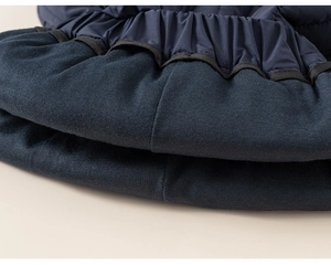 Detailed macro view of navy blue ribbed knit cuffs and windproof fabric stitching